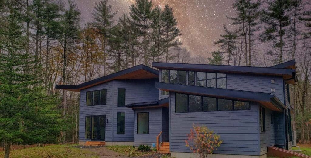 Clapper sturctural engineering residential home project. Blue home sitting in the middle of the woods.